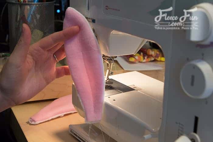 Secure and sew the bunny ears onto the fleece hat following the pattern