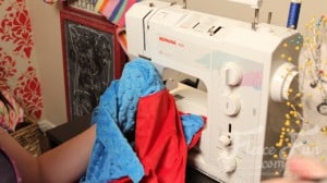 finishing the cape. I love this cute easy superhero cape DIY! It goes around the arms and not the neck for safe play - plus you can turn it around to be a blanket for baby! Easy sewing idea.