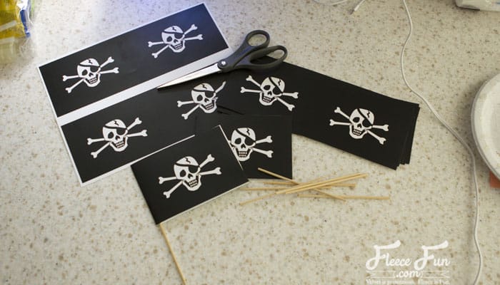 making flags for the centerpiece. I love these pirate centerpieces. These are a perfect pirate party DIY idea. I love these pirate centerpieces. These are a perfect pirate party DIY idea. #pirate #piratepartyideas #piratepartydecor