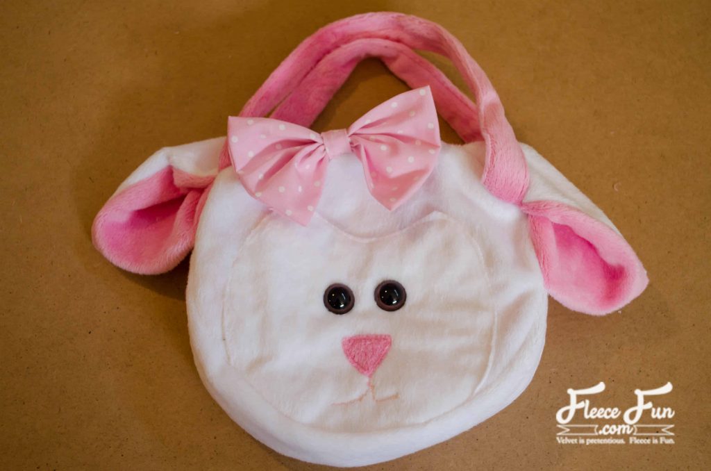 adding the bow to the sheep purse. I love this fleecy sheep purse pattern and tutorial. Such a great handmade gift DIY idea and perfect sewing for a little girl.