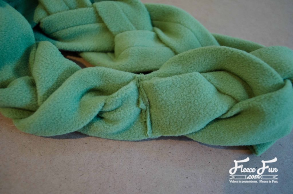 Overlapping the two ends together to finish the braided fleece ear warmer.