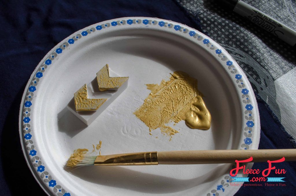 Squeezing a bit of paint on a paper plate.