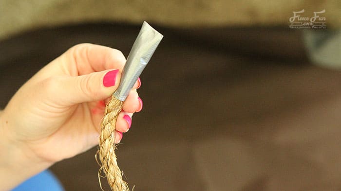 making the drawbridges. adding tape to the ropes. Wow I love this play castle tutorial. Such a great DIY idea for play for kids. Love how it fits onto a card table and folds into a bag when play is done!