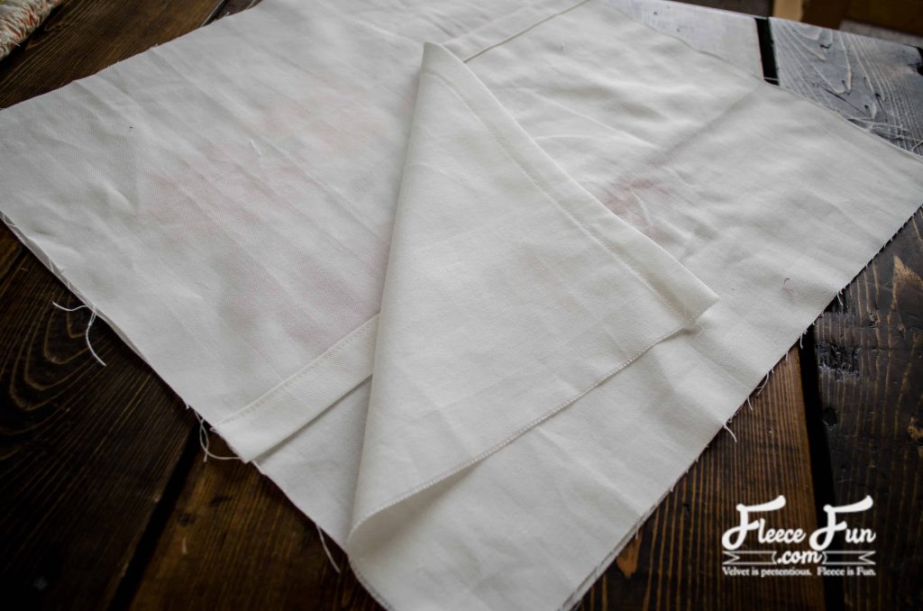 With right sides facing, pin both rectangles to the square with the hemmed edges in the center.