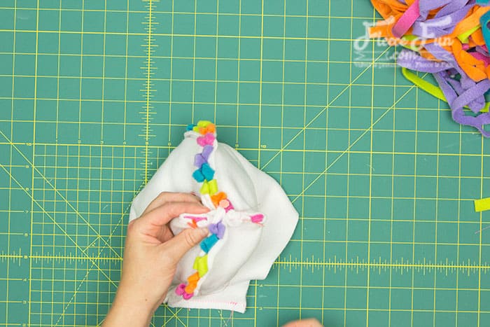 The side of the ear that is folded and shows pink needs to face forward – toward the horn.