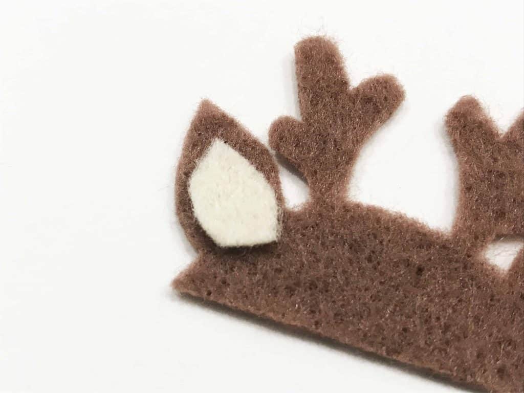 Assembling reindeer head parts following fleecefun step-by-step sewing guide.