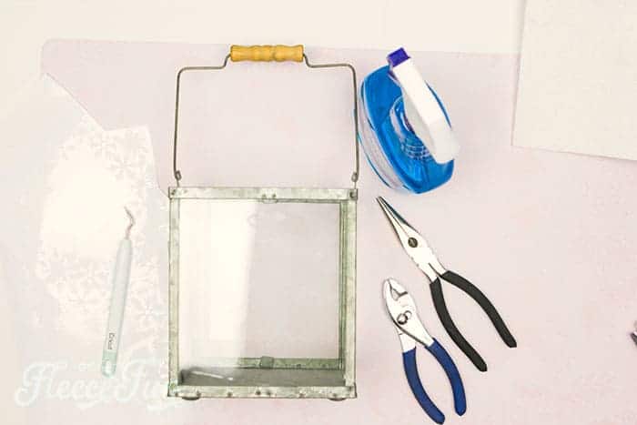 Attaching festive window cling designs to a lantern for a Christmas terrarium from fleecefun's tutorial.