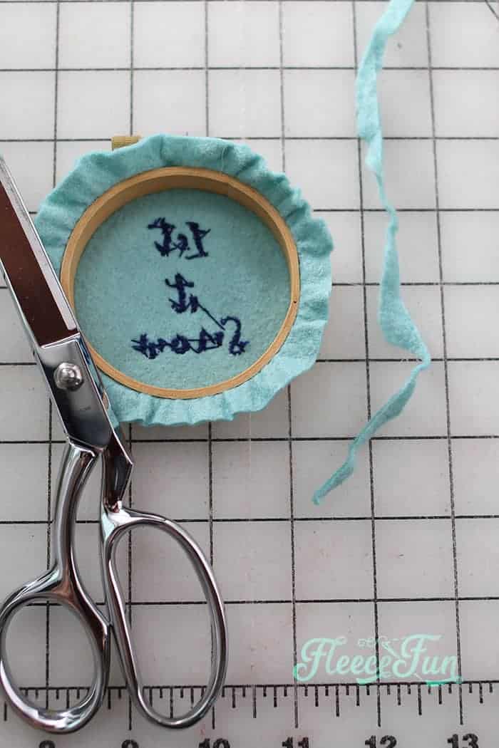 Step 5 of the embroidery hoop ornament: perfectly trimming the felt edges with fleecefun's guide.