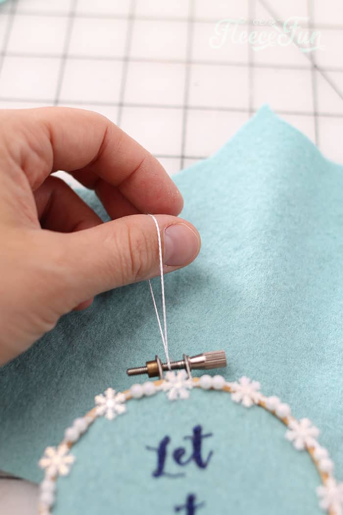 Completing the holiday ornament with a hanging loop in fleecefun's tutorial.
