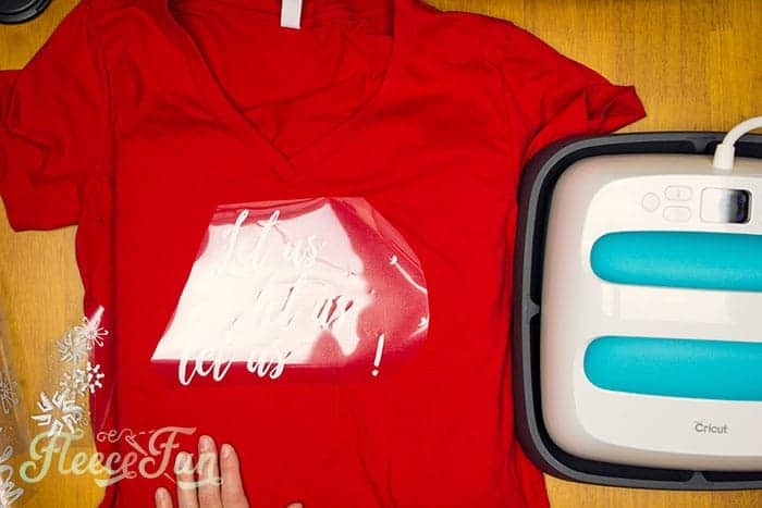 Ironing heat transfer vinyl onto the Let Us Sew festive shirt with fleecefun's free tutorial