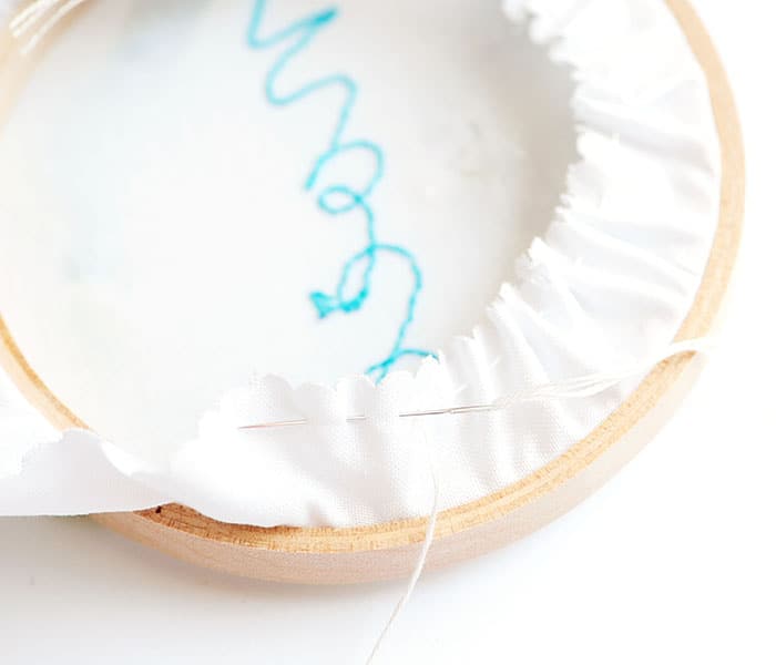 Adding finishing touches to your Noël hoop ornament with fleecefun's free tutorial.