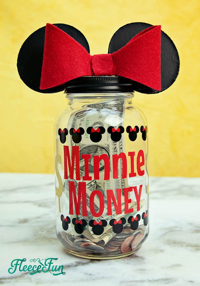 Close-up of a Disney vacation savings jar with cute decorations from fleecefun and free template and tutorial