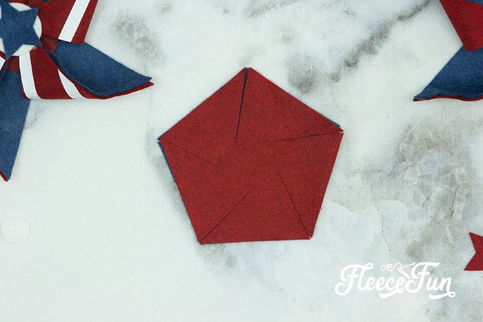 Lining up the two hexagons. There’s just something about red, white, and blue on the front door that makes summer feel official. This DIY Pinwheel Wreath is bold, cheerful, and packed with patriotic charm without looking store-bought. Made with felt pinwheels and a free SVG file, it’s sturdy enough to survive garage mishaps and cute enough to steal the spotlight at your 4th of July party. Ready to spin some Americana magic into your home decor?