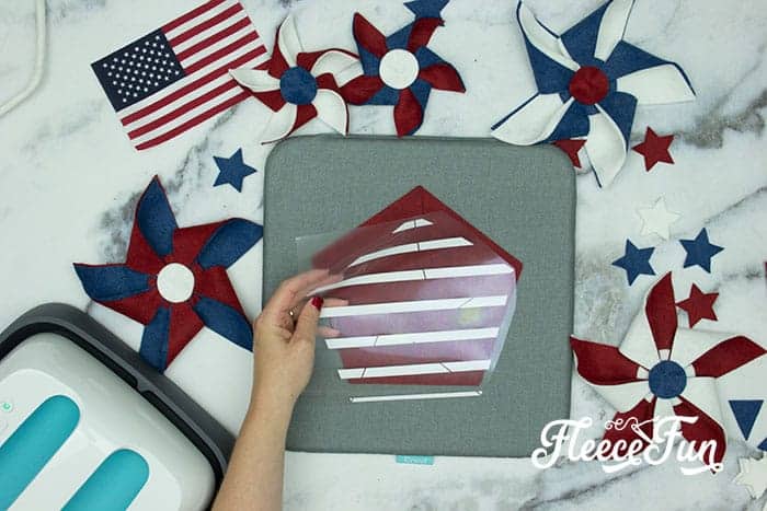 Adding the different HTV patterns. There’s just something about red, white, and blue on the front door that makes summer feel official. This DIY Pinwheel Wreath is bold, cheerful, and packed with patriotic charm without looking store-bought. Made with felt pinwheels and a free SVG file, it’s sturdy enough to survive garage mishaps and cute enough to steal the spotlight at your 4th of July party. Ready to spin some Americana magic into your home decor?