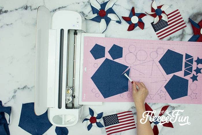 Cutting out one pinwheel each sizes. There’s just something about red, white, and blue on the front door that makes summer feel official. This DIY Pinwheel Wreath is bold, cheerful, and packed with patriotic charm without looking store-bought. Made with felt pinwheels and a free SVG file, it’s sturdy enough to survive garage mishaps and cute enough to steal the spotlight at your 4th of July party. Ready to spin some Americana magic into your home decor?