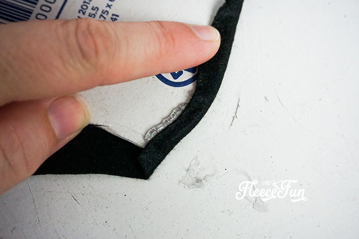 Wrapping the extra fabric for ears around to the front of the cardboard cutout.