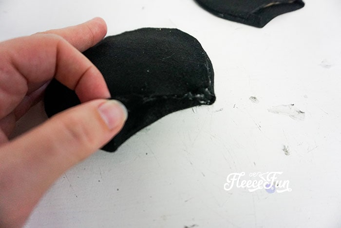 Affixing the smaller black felt ear cutout .