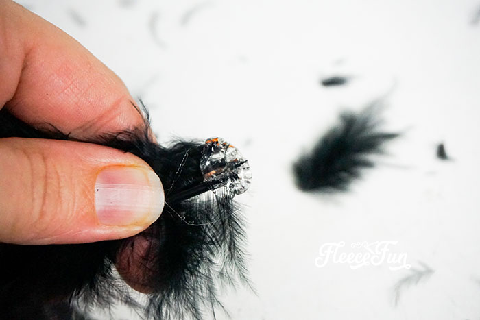 Pinching the half of the feathers together.