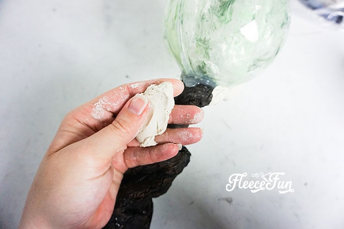 Affix the ornament to the end of the staff with hot glue.