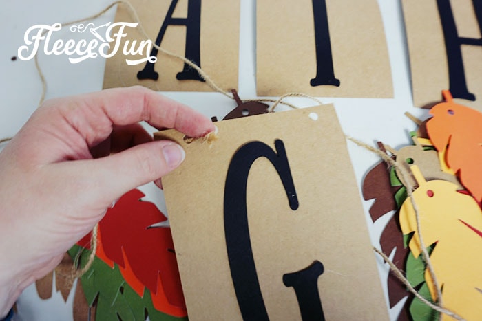Start threading on the feathers and letters in order on the twine.