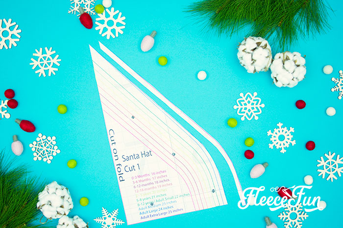 Preparing the fabric by cutting out the Santa hat pattern from fleecefun's free template and tutorial