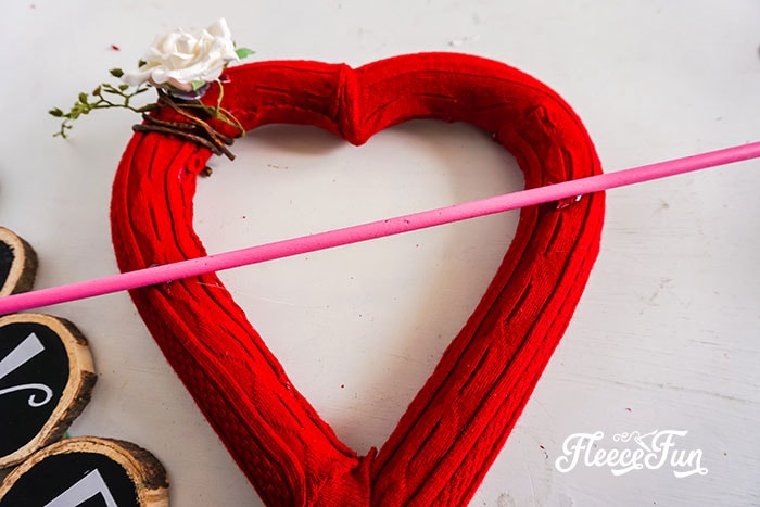 DIY Valentine arrow crafting guided by fleecefun's free wreath-making instructions.