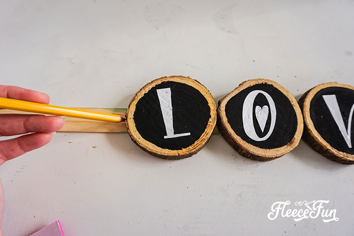 Step-by-step process for adding a love sign to the Valentine wreath with fleecefun's tutorial.