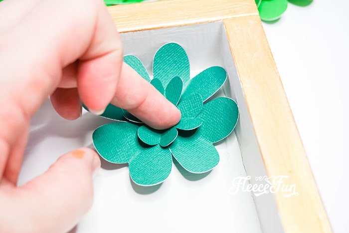 hot gluing the clovers on the shadow box