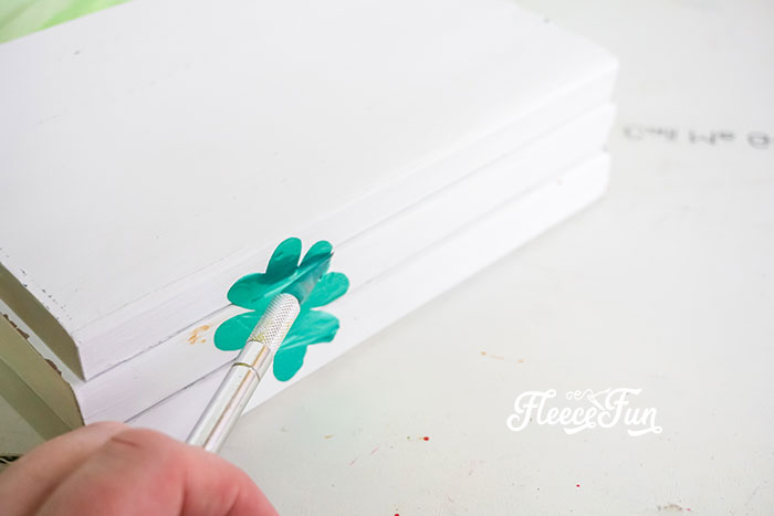 Applying heat transfer vinyl to complete a stylish St. Patrick’s Day decoration with fleecefun and free template and tutorial