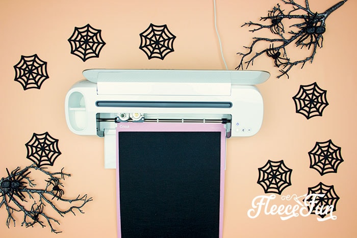 Cutting out bat shapes for the DIY Halloween garland with fleecefun free template and tutorial.