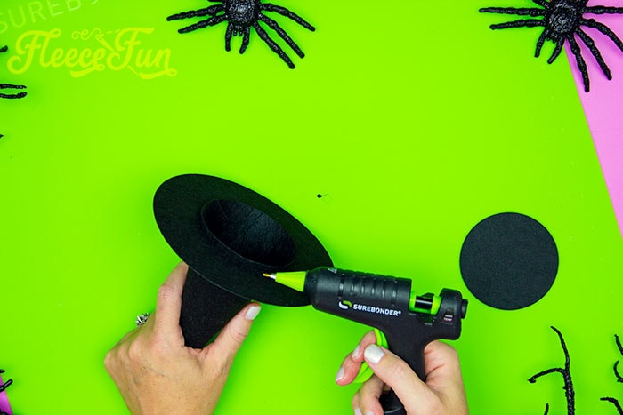 Gluing the brim to the cone. This DIY Mini Witch Hat is no sew and comes with a free PDF pattern and SVG template to make it a breeze! 3 mini sizes so you can make the perfect hat!