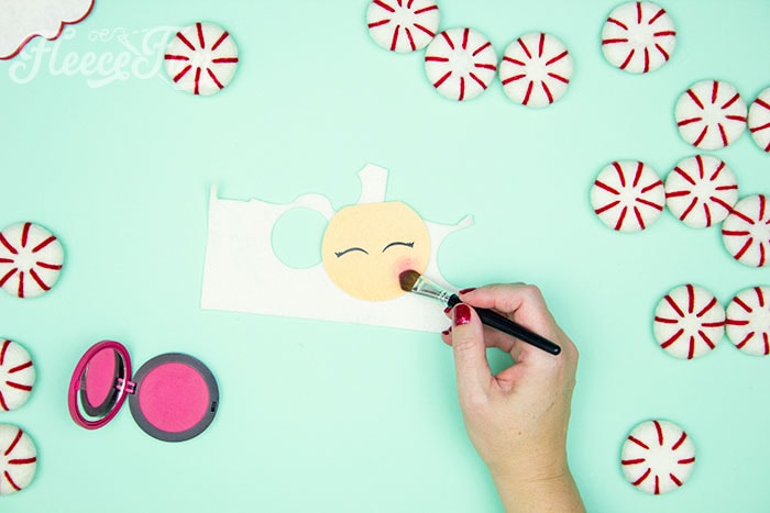 Adding rosy cheeks and a nose to the felt Santa ornament with fleecefun's free template and tutorial.