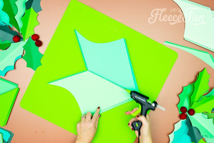 Assembling and gluing holly leaves together with fleecefun's DIY tutorial.