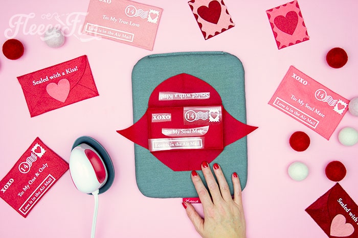 Applying heat transfer vinyl to the felt Valentine envelope, following fleecefun's DIY tutorial.