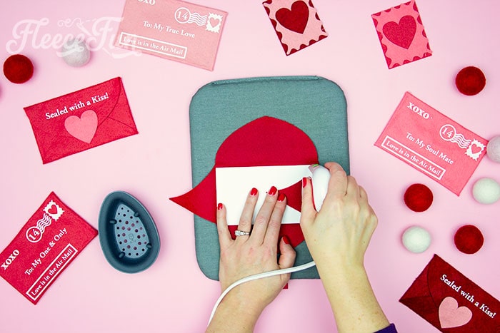 ironing along the edge to make a crease for a Valentine envelope project inspired by fleecefun's step-by-step guide.