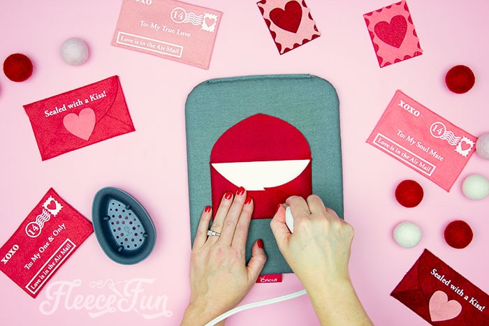 ironing a crease along the fold for a Valentine envelope project inspired by fleecefun's step-by-step guide.