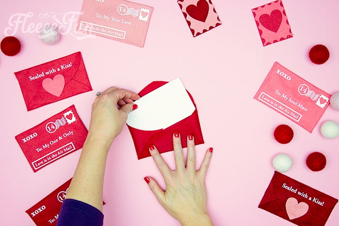 Finishing touches applied to a felt Valentine envelope crafted from fleecefun's no-sew DIY guide.