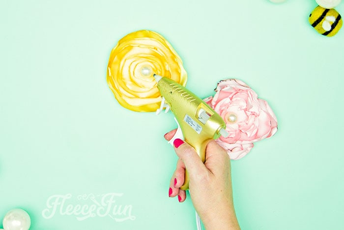 adding the jewel center to the fabric flower DIY.