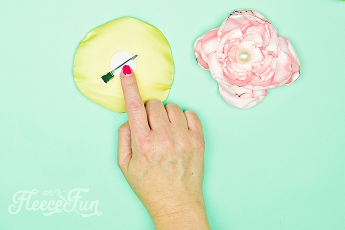 Completing the fabric flower by adding a clip with fleecefun’s step-by-step guide