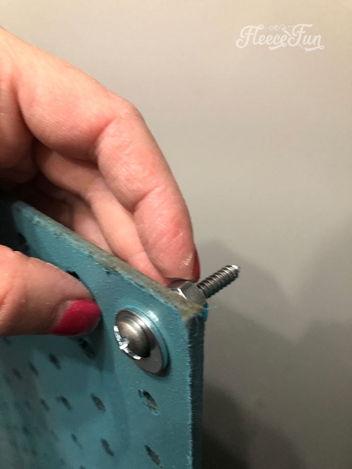 Placing the screws, nuts, and washers into the hole.