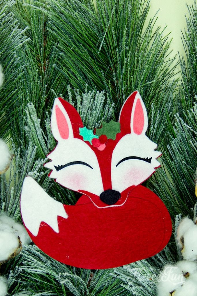 This adorable Felt Fox Ornament DIY (Free Pattern) is a fun addition to your Christmas tree Ornaments!  Curled up in it's tail with a bit of holly on it's head this fox is the embodiment of merriment.  Use for tree decorations or as a fun addition to a wrapped gift.  Also makes a wonderful hostess gift or prize at a holiday party. Perfect handmade ornament to make.
