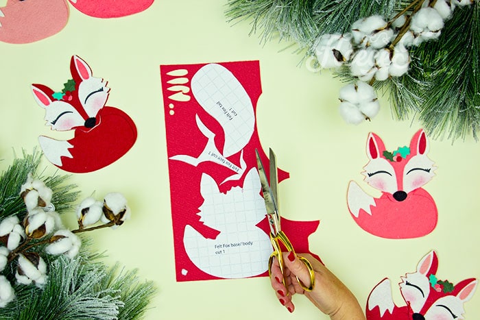 Cutting out the pattern. This adorable Felt Fox Ornament DIY (Free Pattern) is a fun addition to your Christmas tree Ornaments!  Curled up in it's tail with a bit of holly on it's head this fox is the embodiment of merriment.  Use for tree decorations or as a fun addition to a wrapped gift.  Also makes a wonderful hostess gift or prize at a holiday party. Perfect handmade ornament to make.