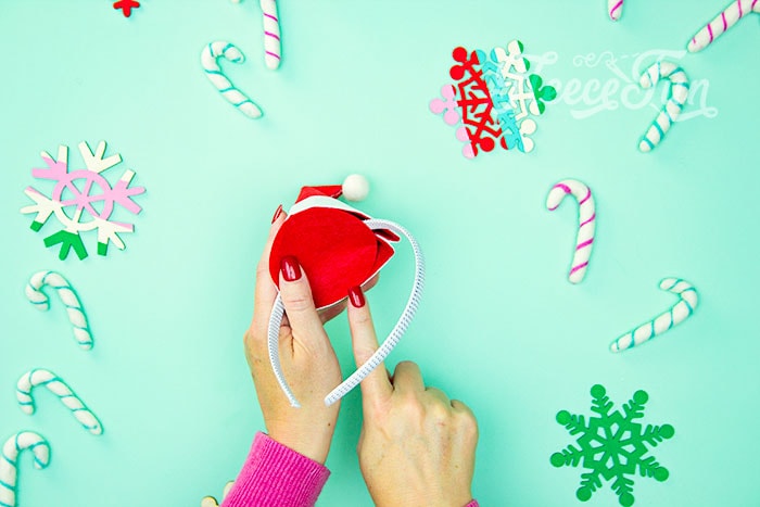 Securing the Santa hat to your DIY headband using fleecefun’s tutorial