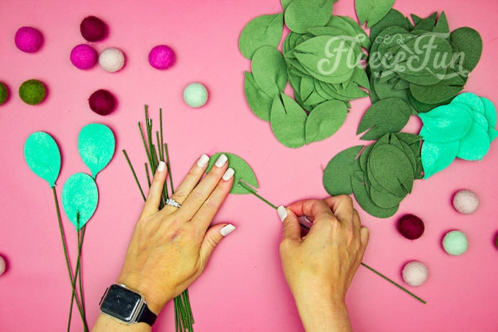 Glueing leave sto wire continued. This modern Christmas Wreath DIY (made from felt) is a whimsical addition to your holiday décor. With a few items you can make this festive wreath. Because of the way it's constructed no two are alike. Make it as full or as thin as your taste's desire. Because it's made from felt, this wreath can be made in an array of colors to suit your style.