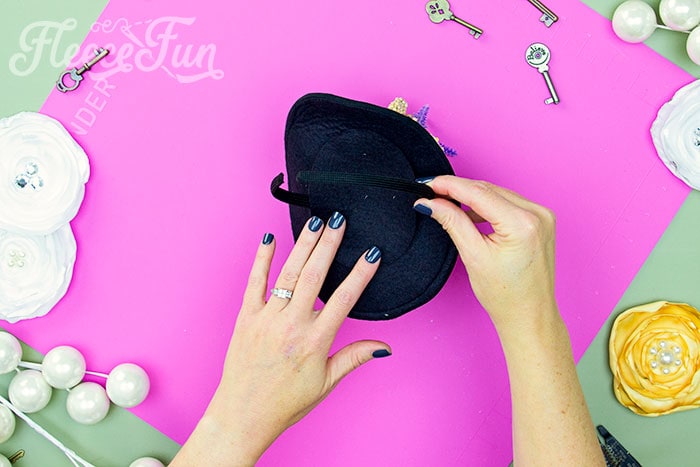 Adding a headband to the mini top hat. Learn how to make a mini top hat with this free pattern and tutorial. I love that there is a sew and no sew option. The free template makes this costume idea easy to make at home. 