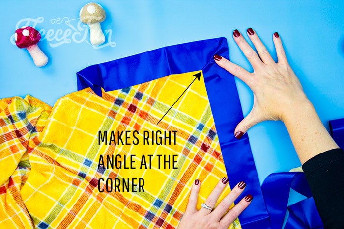 Step-by-step guide to mitering corners on a satin-bound fleece blanket in fleecefun’s tutorial