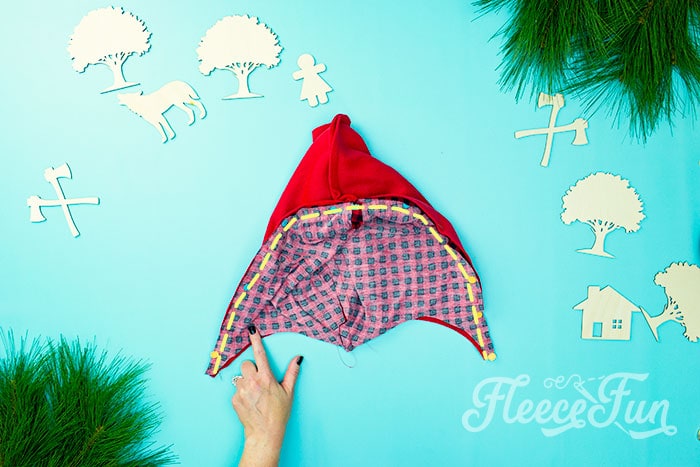 showing how to sew along the edge of the red riding hood to add the lining.