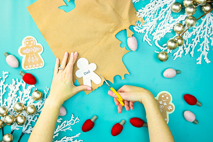 Cutting out the Gingerbread Family pieces using fleecefun free template for DIY ornaments.