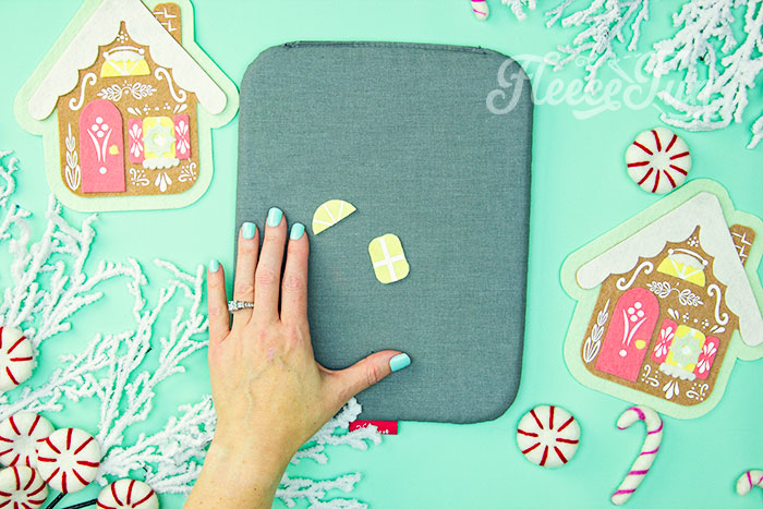 Applying decorative HTV to the gingerbread house felt ornament with fleecefun free template