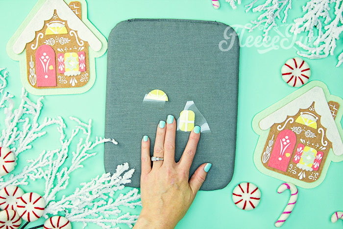 Personalizing the felt gingerbread house ornament with HTV from fleecefun’s free pattern